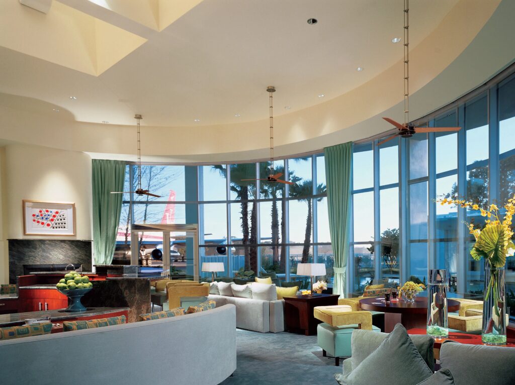 Interior living room of John Travolta house with large windows overlooking private runway aviation estate
